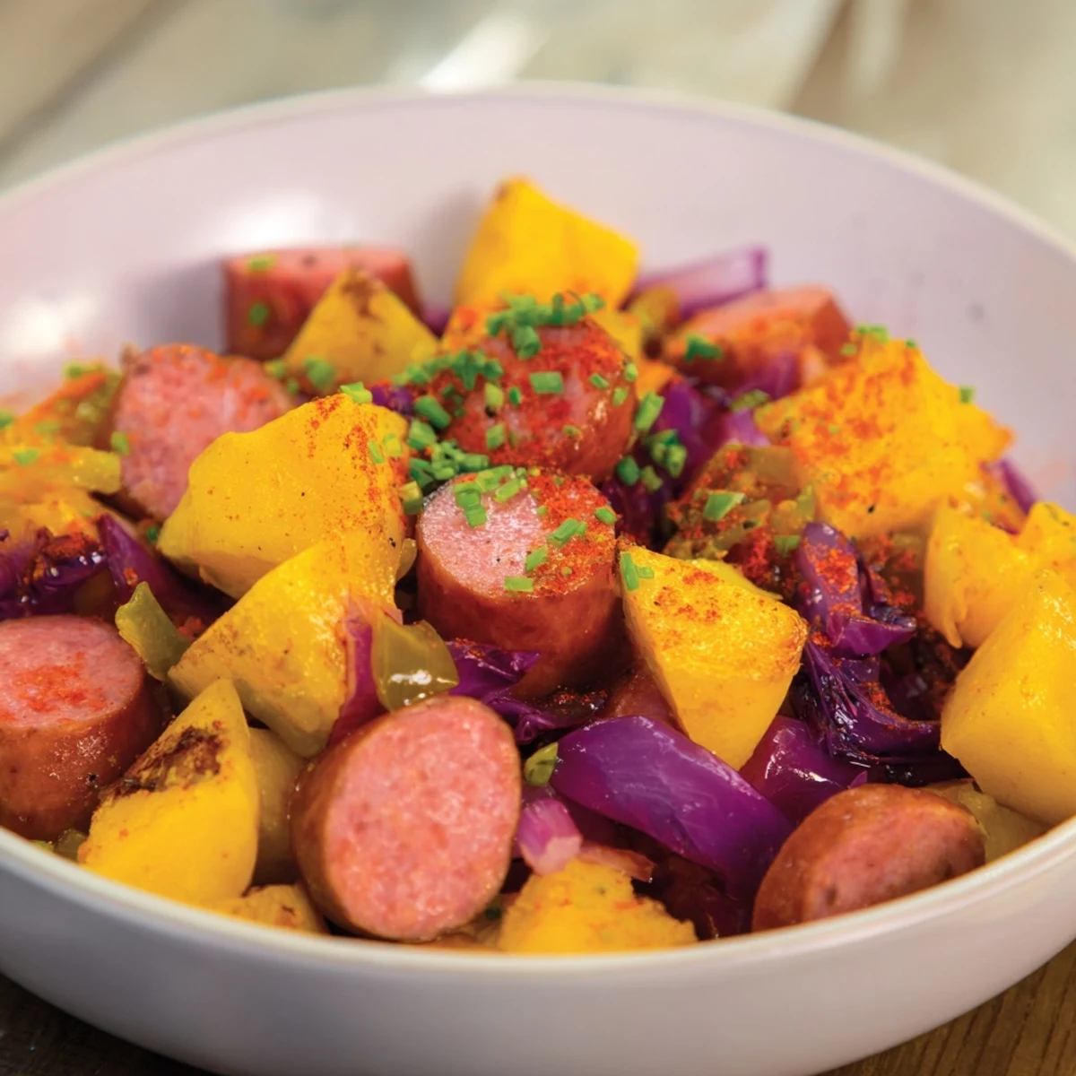 Smoky kielbasa and tender cabbage mingling in our Rustic Flint-Style Skillet Plate, sizzling.