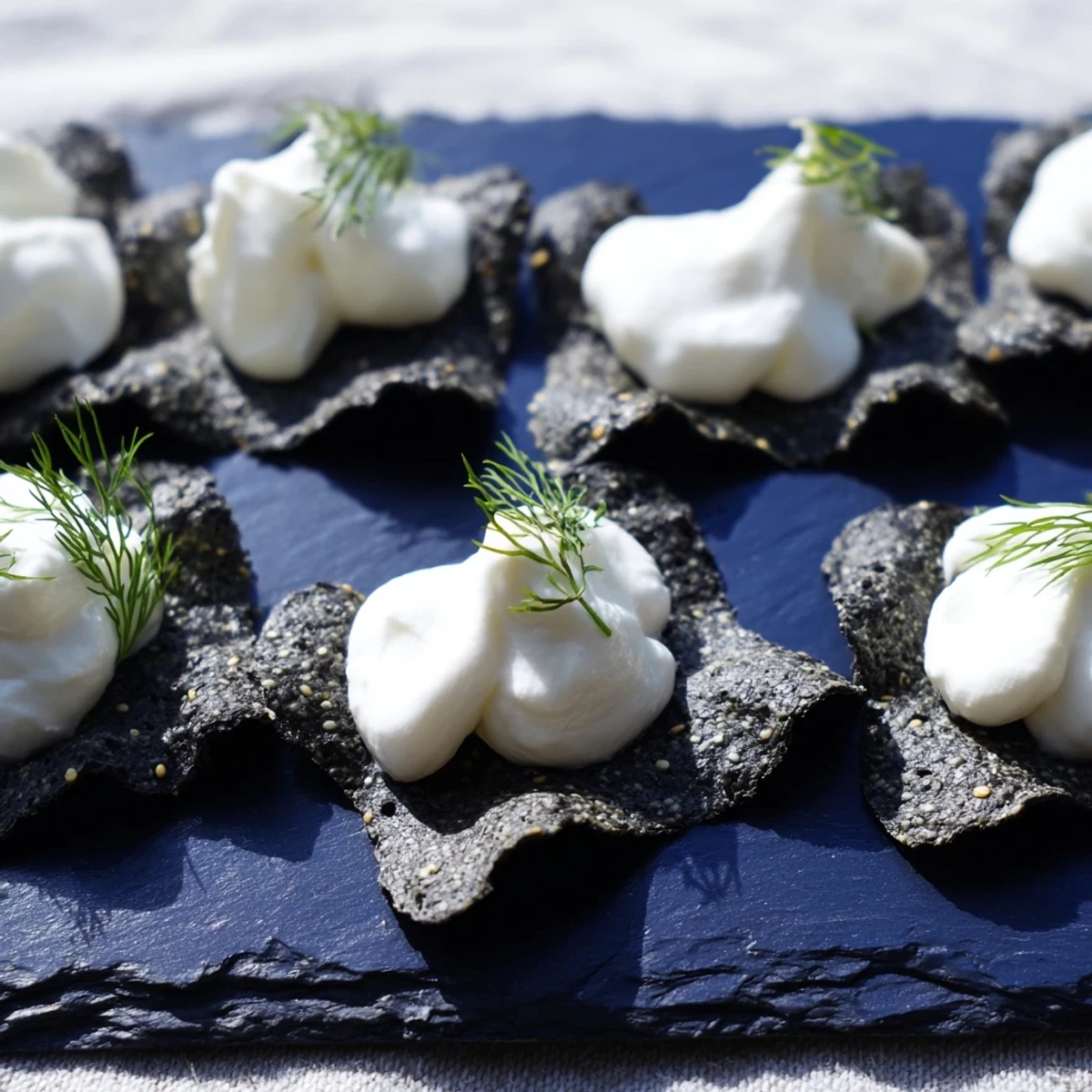 Appetizing "Stormy Sea" crackers topped with creamy goat cheese, ready to grab and enjoy.