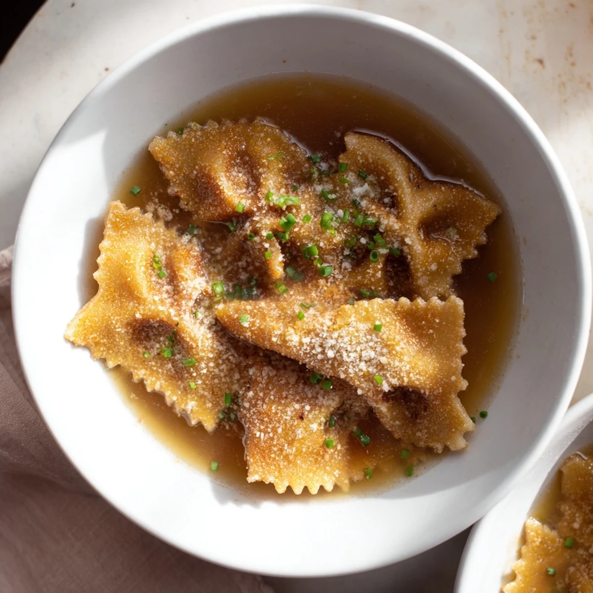 Golden, crispy Pasta Chip Cereal in a bowl, swimming in rich parmesan broth, offering a savory start.
