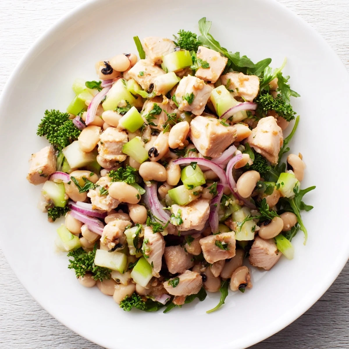 Chicken and Apple New Years Luck Salad, tossed with a tangy dressing, awaits fresh and vibrant in a bowl.