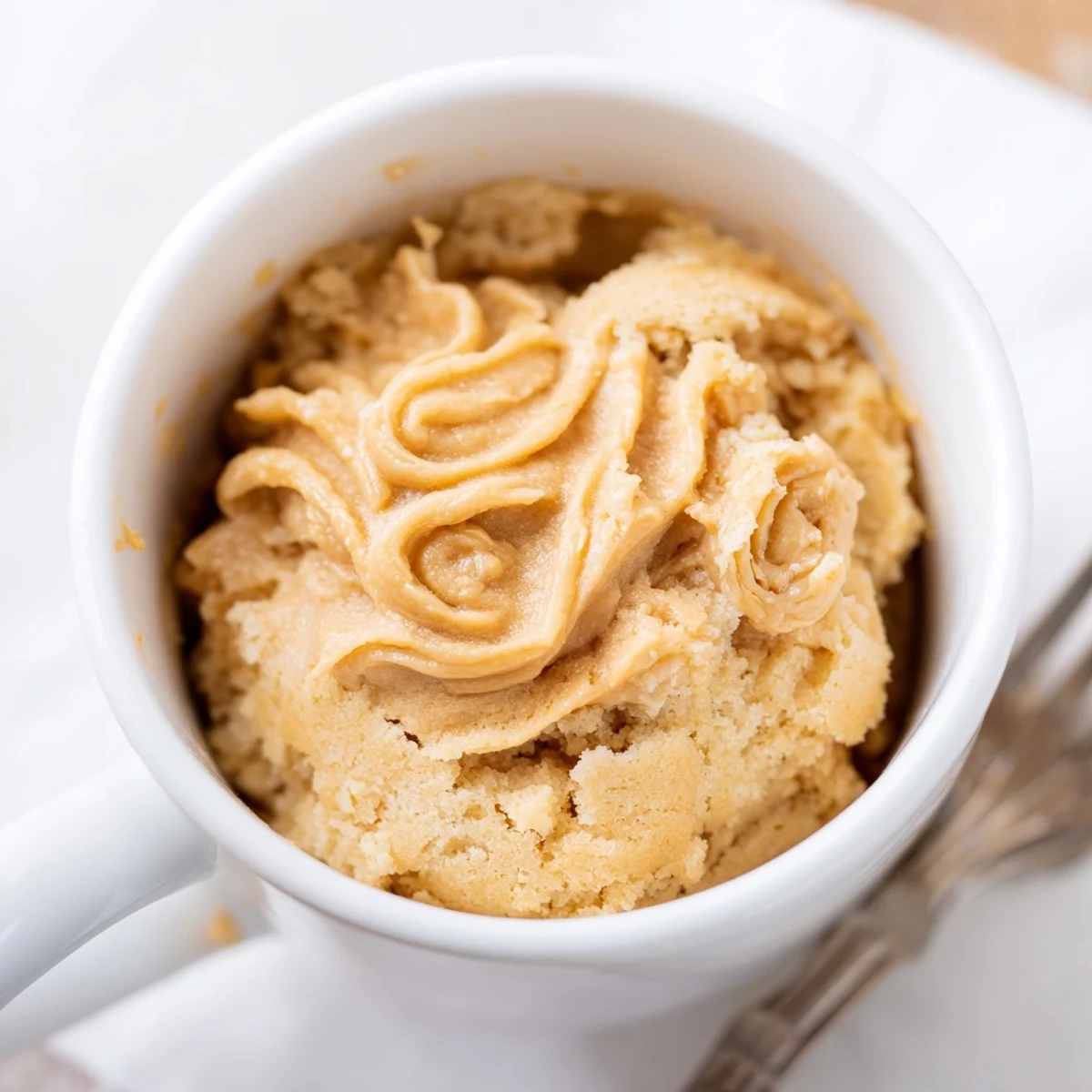 Steaming warm 2-Minute Peanut Butter Mug Cake, a quick chocolate-chip-studded dessert, ready to enjoy.
