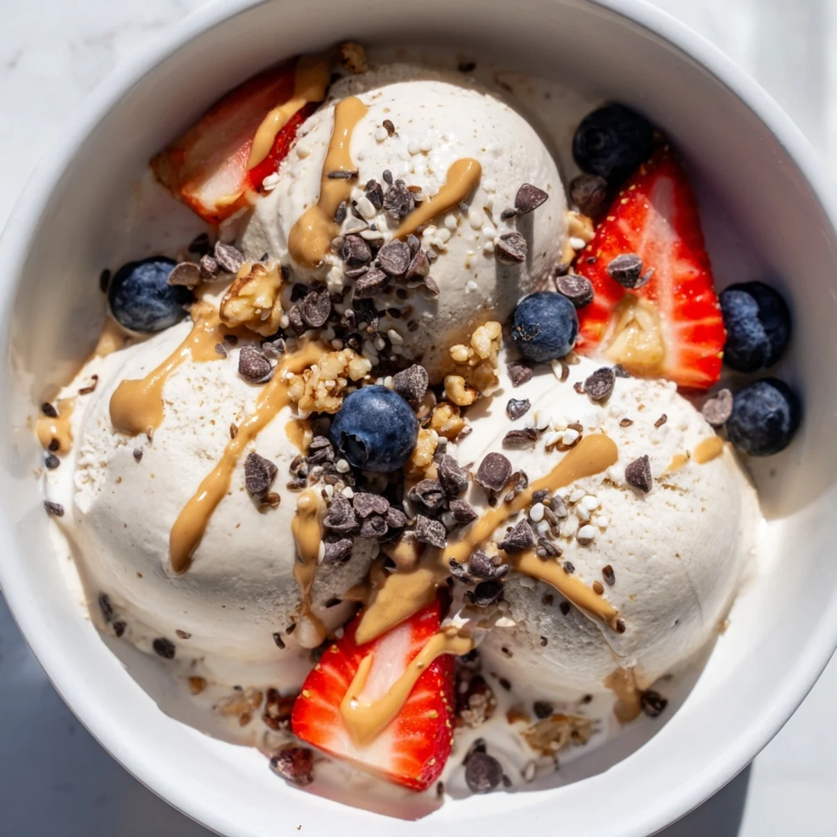 Creamy, homemade Protein Ice Cream Bowl topped with fresh berries and dark chocolate chips.