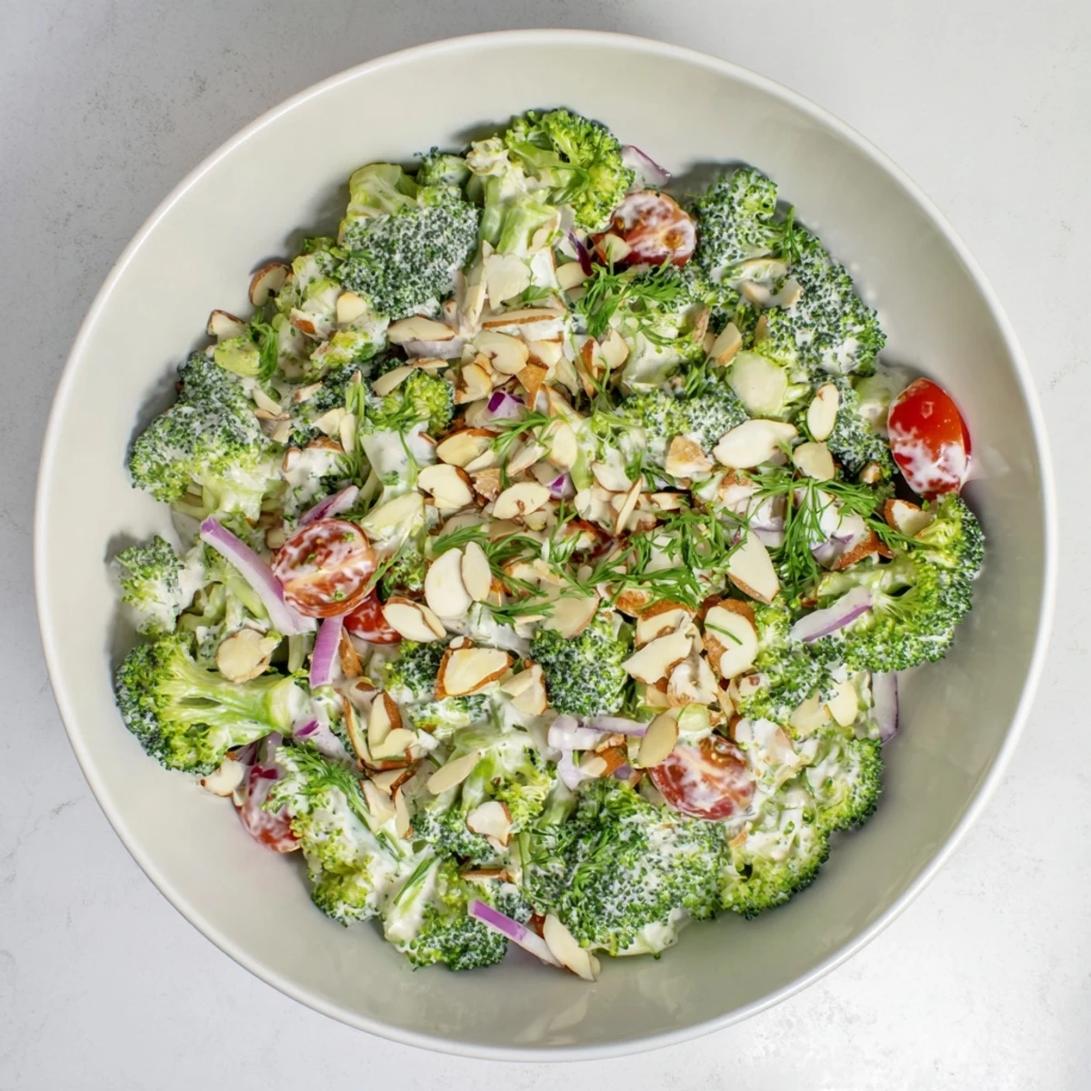 Ready-to-serve Garlic Parmesan Broccoli Salad garnished with parsley, paired with grilled chicken for an easy side dish.
