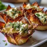 Freshly baked Mediterranean Spinach and Feta Cheese Crisps garnished with sesame seeds and lemon zest. 