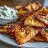 Homemade pita chips with tzatziki, golden and crispy, served with a cool cucumber-yogurt dip for dipping.