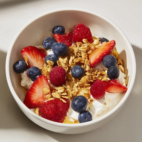 A vibrant Cottage Cheese Hot Honey Bowl with a drizzle of spicy honey over fresh berries.