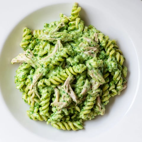 Creamy Cilantro Lime Chicken Pasta served in a bowl, topped with crumbled feta and fresh lime wedges.  