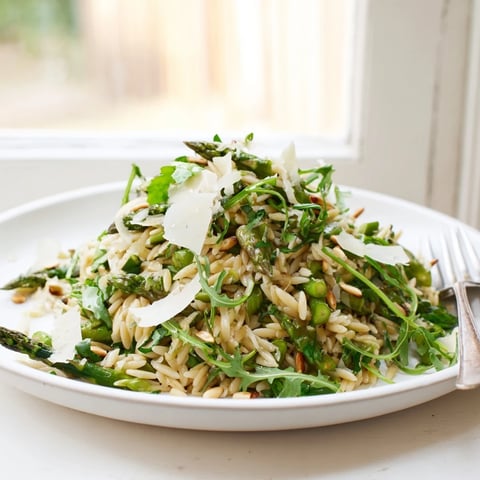 Shaved asparagus ribbons and tender orzo pasta are tossed in a bright lemon vinaigrette, with toasted pine nuts and grated Parmesan in this vibrant Asparagus Lemon Orzo Salad.