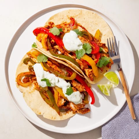 Golden Chicken Fajitas with Lime Crema, stuffed into warm tortillas, garnished with cilantro.
