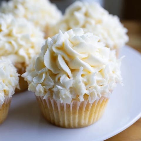 Homemade vanilla cupcakes with swirls of creamy buttercream frosting, a sweet treat you can bake.