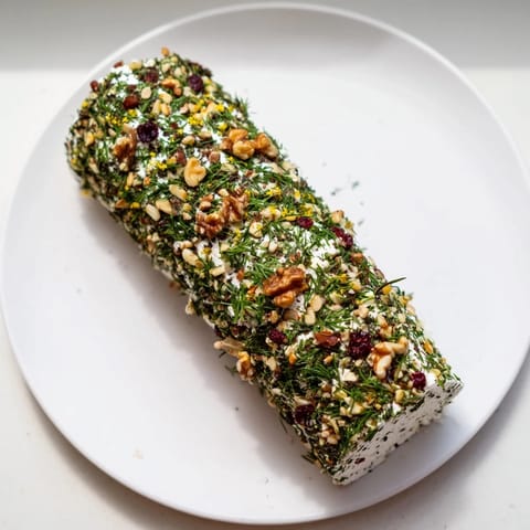 Vibrantly coated Winter Snowdrift Goat Cheese Log, perfect appetizer for sharing with friends and family.