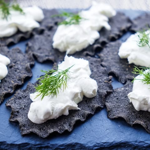 A close-up of "The Stormy Sea," showing grey crackers with white goat cheese dollops.