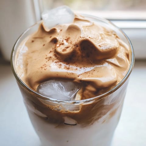 Swirls of fluffy Brown Sugar Dalgona Latte coffee mixture provide a sweet contrast to cold milk.