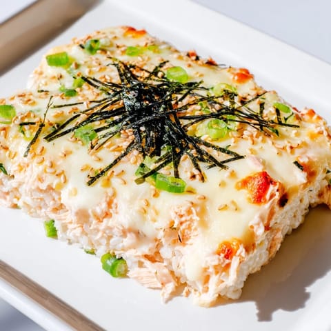 Golden bubbly baked Creamy Salmon Sushi Bake, a warm casserole featuring flaky salmon and creamy sauce.