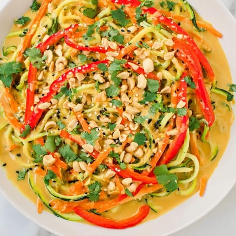 Fresh Zesty Peanut Zucchini Noodles salad with vibrant bell peppers and a sprinkle of peanuts.