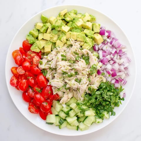 Colorful bowl of Avocado Chicken Salad featuring diced avocado and crisp cucumber, perfect for a refreshing light lunch or healthy meal prep.