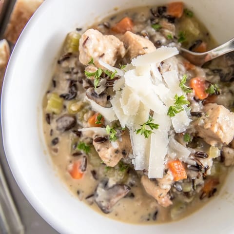 Hearty bowl of Parmesan Mushroom Chicken and Wild Rice Soup with tender chicken, mushrooms, and wild rice.