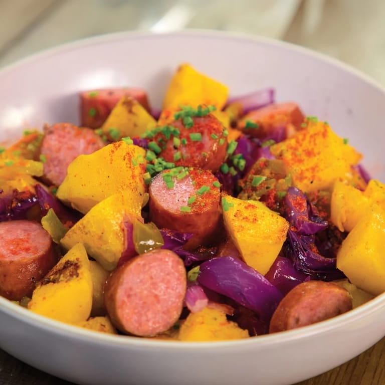 Smoky kielbasa and tender cabbage mingling in our Rustic Flint-Style Skillet Plate, sizzling.