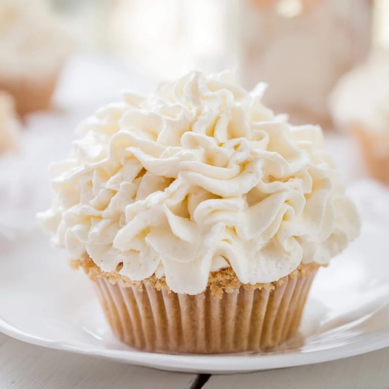 These delicious vanilla cupcakes feature a generous topping of perfectly smooth buttercream frosting, ready to eat.