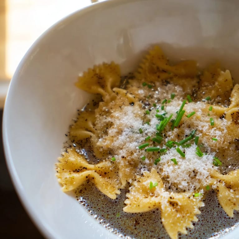 A close-up of Pasta Chip Cereal with parmesan-infused broth, perfect for a fun, warm snack.
