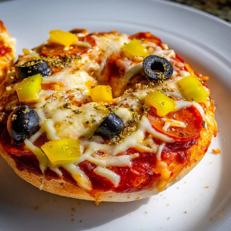 Golden, crispy mini bagel pizzas, a quick snack featuring melty mozzarella and flavorful toppings.