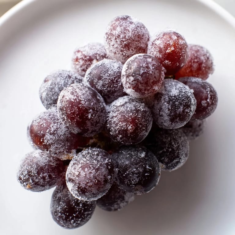 Sweet, frosted frozen grapes, perfect for a summer treat, bursting with cold, juicy flavor.
