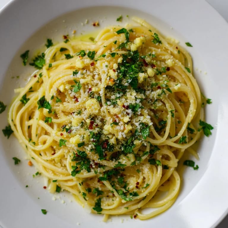 Creamy garlic butter linguine, served with fresh lemon wedges, offers a simple and flavorful meal.