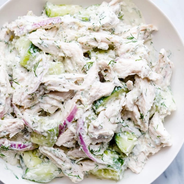 Bright and refreshing Creamy Cucumber Chicken Salad in a glass bowl, featuring diced chicken and thinly sliced cucumbers in creamy yogurt dressing.