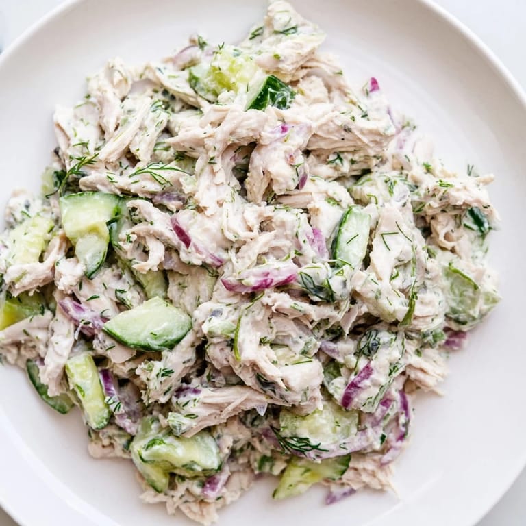 Creamy Cucumber Chicken Salad served on a wooden board with herbs and lemon wedges, perfect for a healthy summer lunch.