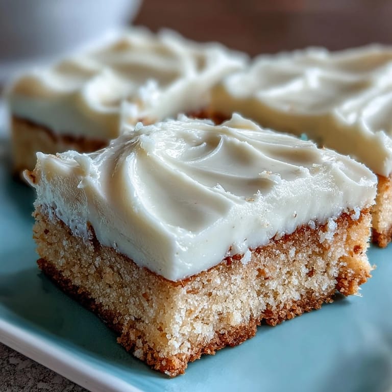 A close-up shows soft, chewy Almond Flour Sugar Cookie Bars, topped with smooth frosting and sprinkles.