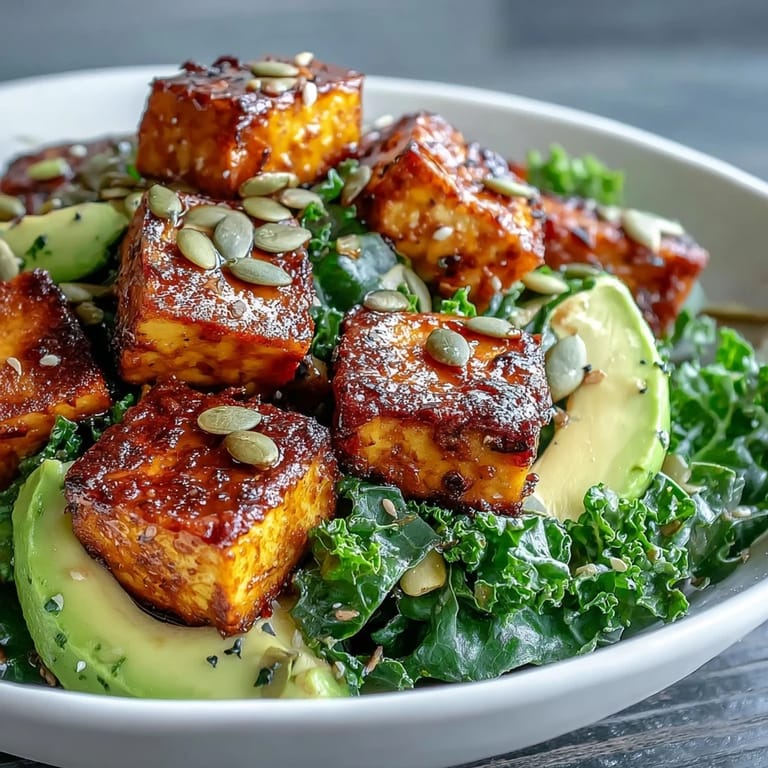 Wholesome tofu and kale breakfast bowl topped with ripe avocado, smoked paprika tofu, and a sprinkle of nutritional yeast for a savory vegan meal.